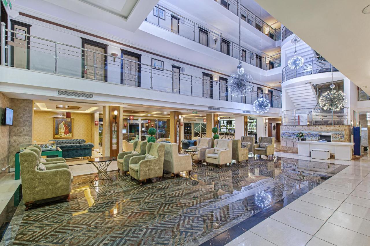 Sealife Family Resort Hotel Antalya Luaran gambar The image shows a spacious hotel lobby with a modern and elegant design. The area features a high ceiling with multiple levels, large windows allowing natural light to filter in, and stylish decor elements. There are comfortable seating arrangements 