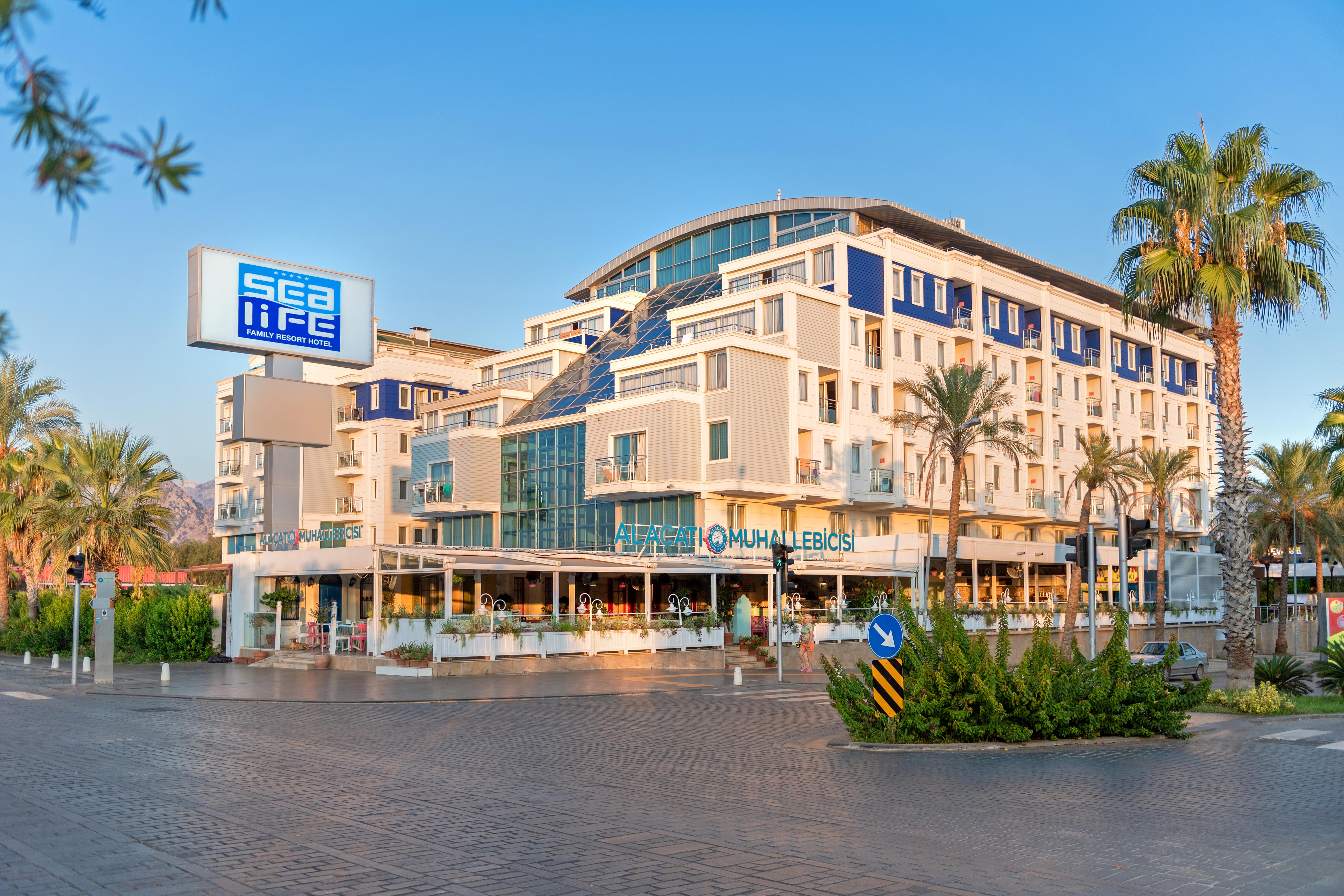 Sealife Family Resort Hotel Antalya Luaran gambar The photo shows a modern building with a contemporary architectural design, featuring multiple levels and large glass windows. There is a sign that reads "sea life" prominently displayed on the left. The building appears to house a restaurant or café